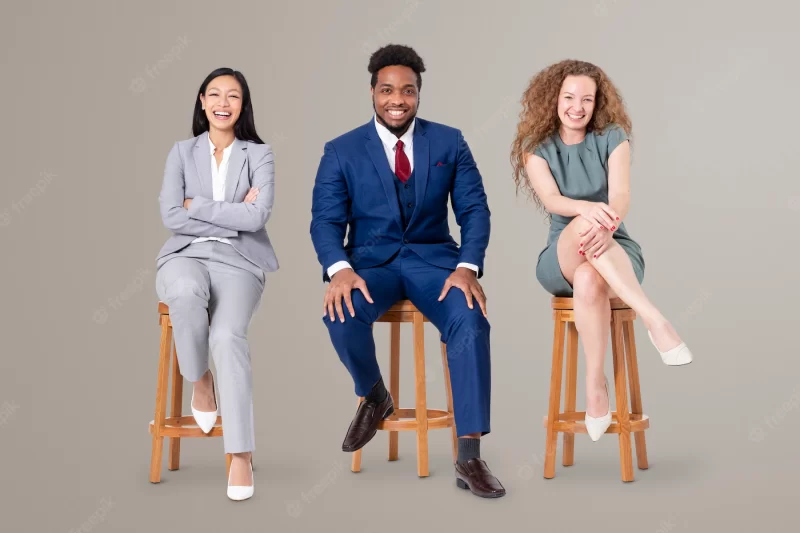 African black man sitting on a wooden stool between 2 ladies