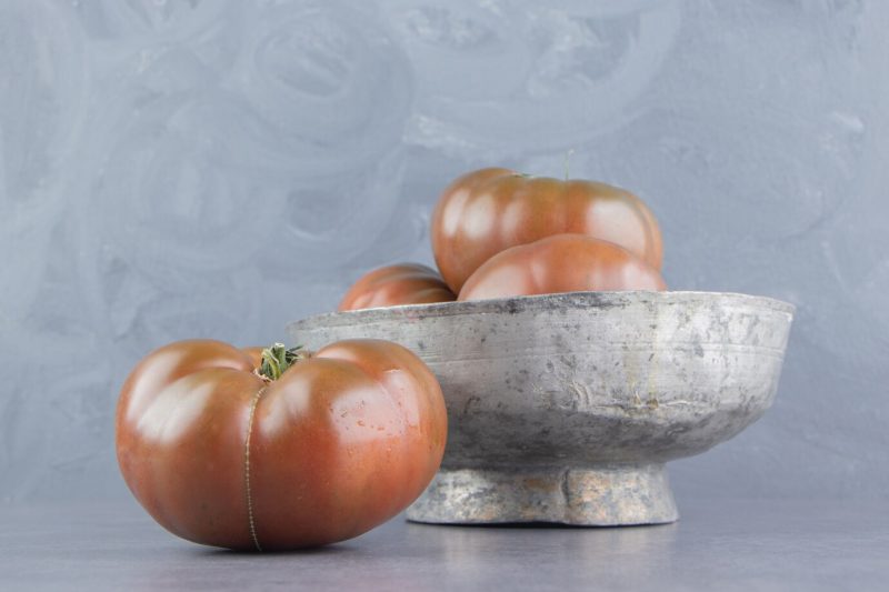 Tasty tomato in the bowl, on the marble surface Free Photo