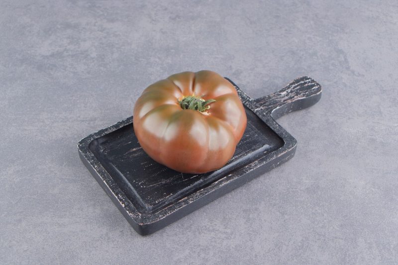 Tomatoes in the board,on the marble surface Free Photo