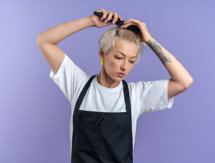 Unpleased Looking Down Young Beautiful Female Barber Uniform Combing Hair Isolated Blue Background 141793 119376
