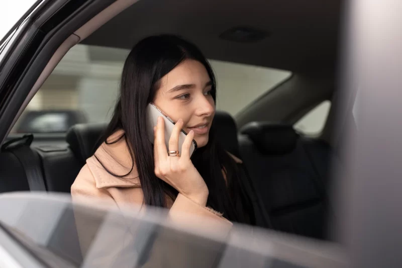 Woman talking on the phone while being in a taxi Free Photo