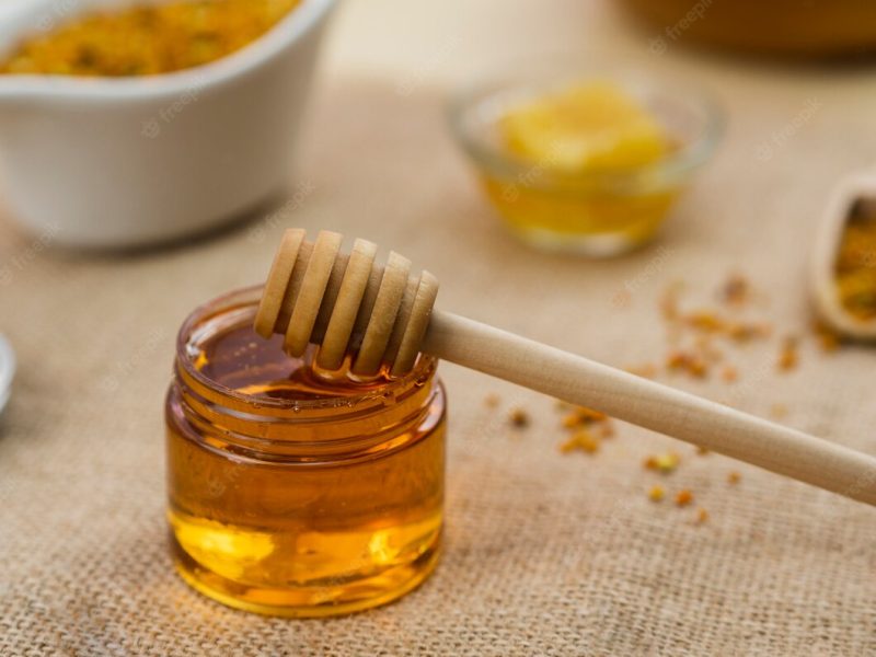 Wooden dipper in sticky honey Free Photo