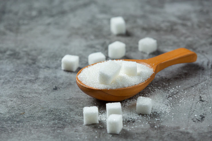 World diabetes day; sugar in wooden bowl on dark surface Free Photo