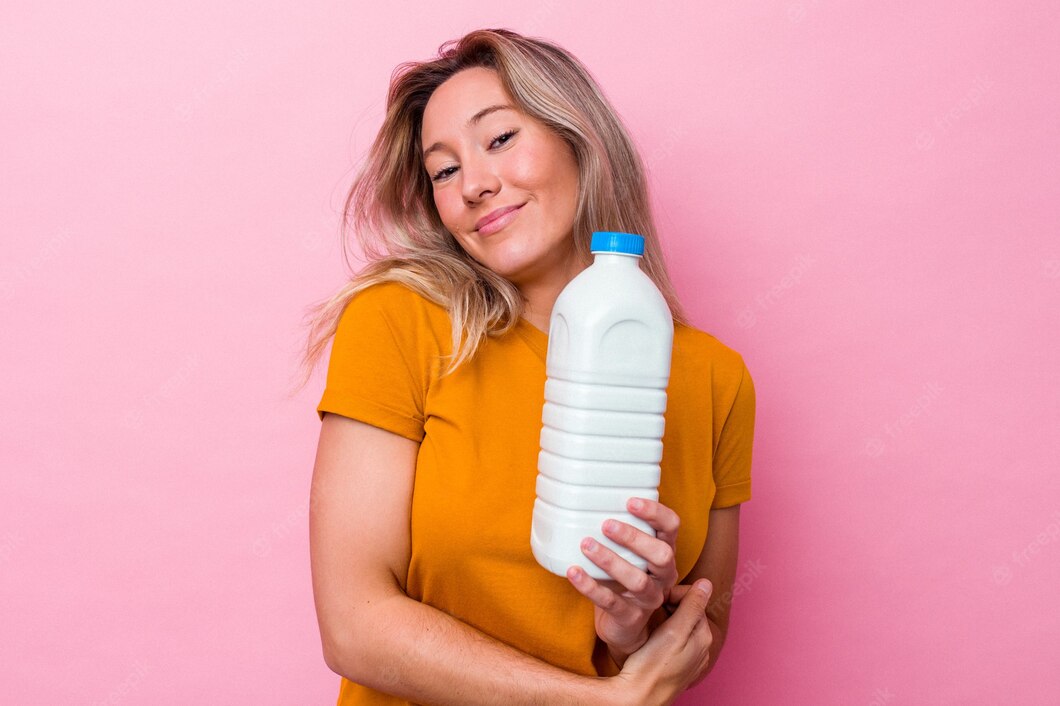 Young Australian Woman Holding Bottle Milk Isolated Pink Background Laughing Having Fun 1187 145045