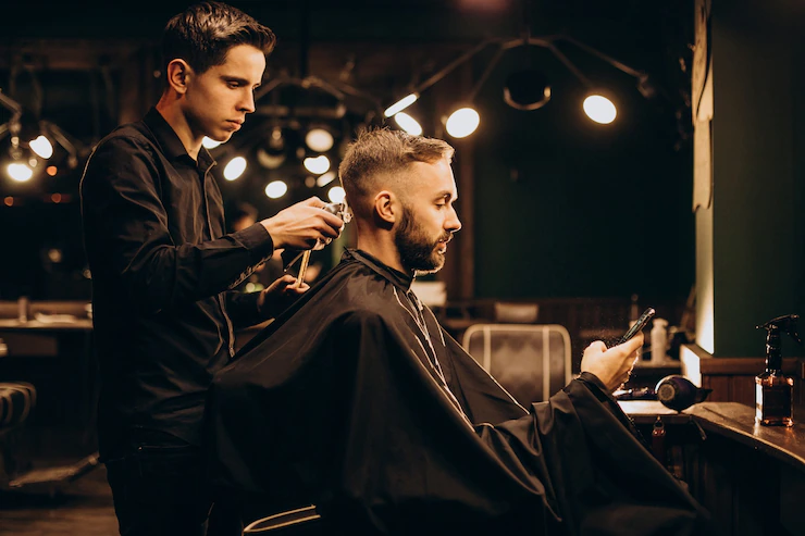 Young man at barbershop trimming hair Free Photo