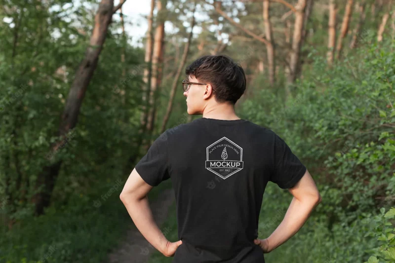 Young man wearing a mock-up t-shirt in the forest Premium Psd