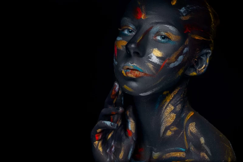 Young woman who is posing covered with black paint Free Photo