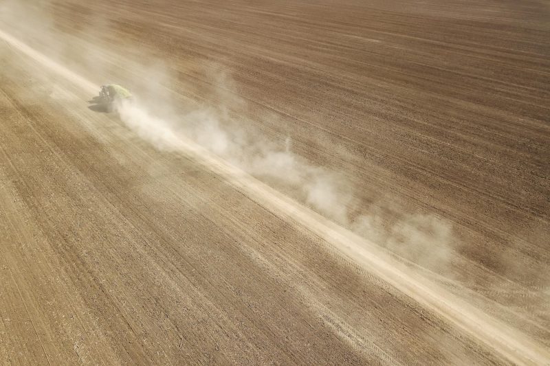 Aerial view dirt road crossing plowed field Free Photo