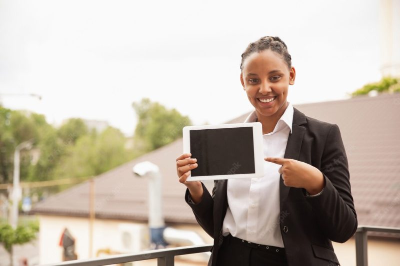 African-american businesswoman in office attire smiling, looks confident and happy, successful Free Photo