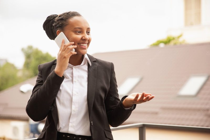 African-american businesswoman in office attire smiling, looks confident and happy, successful Free Photo