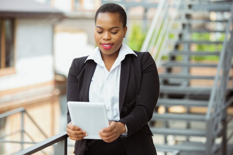 African american businesswoman in office attire using tablet Free Photo