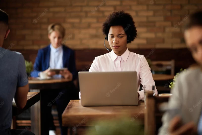 African american businesswoman working on laptop in a cafe Free Photo