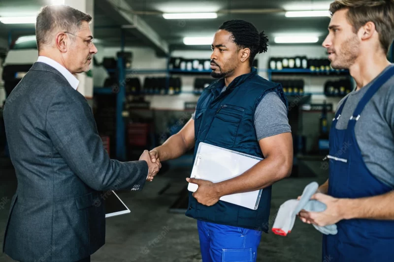 African american car mechanic shaking hands with a manager in auto repair shop Free Photo