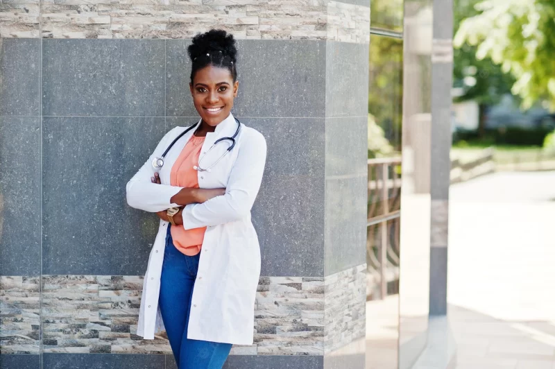 African american doctor female at lab coat with stethoscope posed outdoor against clinic Free Photo