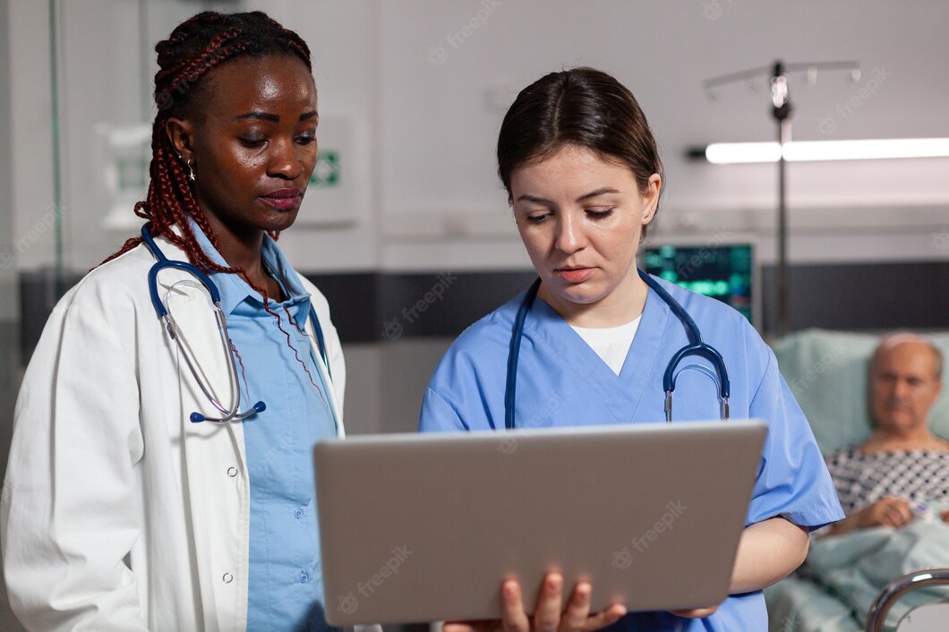 African American Doctor Health Specialist Assistant Using Laptop Discussing Talking Treatment Diagnosis Hospital Room With Sick Patient Laying Bed With Iv Drip Attached 482257 16328