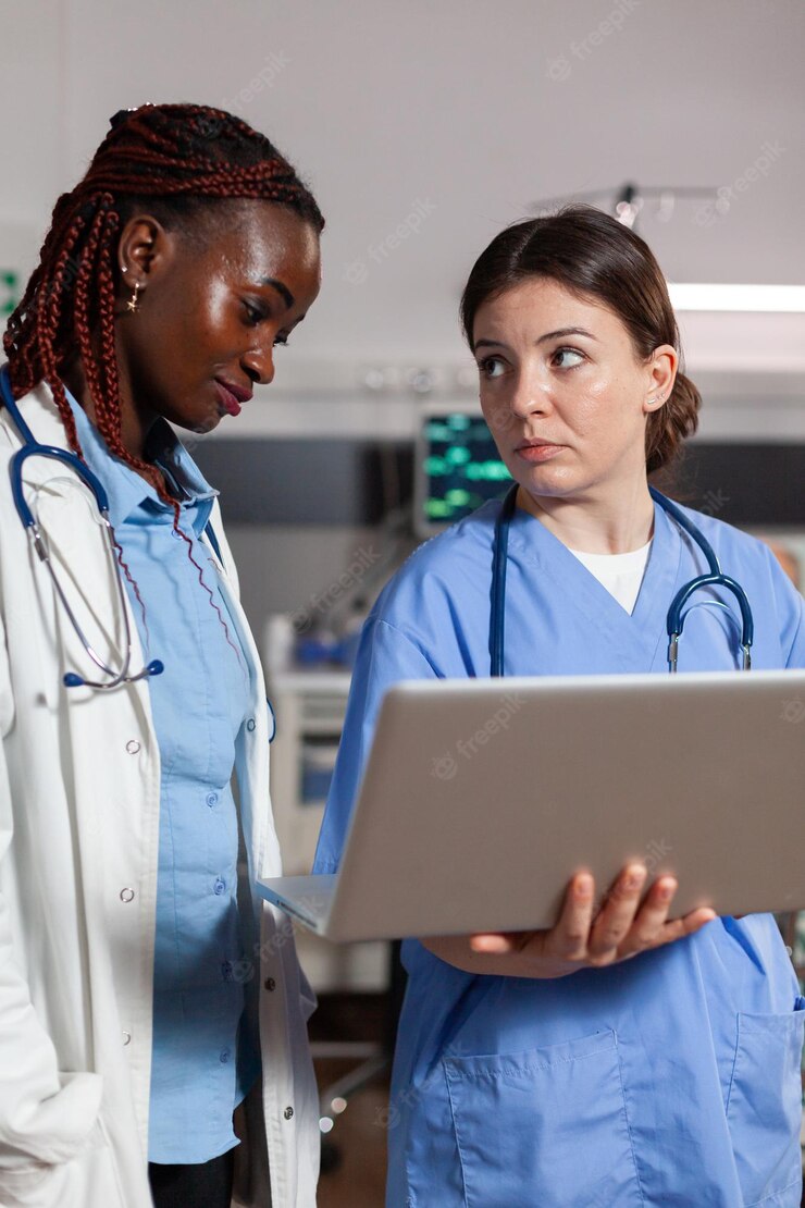 African American Doctor Health Specialist Assistant Using Laptop Discussing Talking Treatment Diagnosis Hospital Room With Sick Patient Laying Bed With Iv Drip Attached 482257 16343