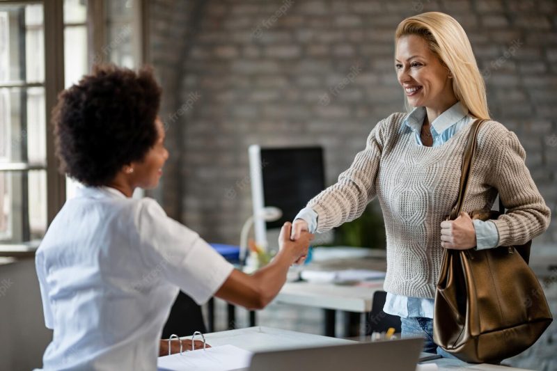 African American doctor shaking hands with her female patient while meeting at the clinic focus is on happy woman Free Photo