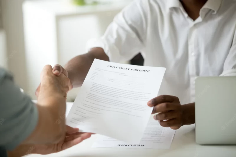 African-american employer holding employment agreement handshaking candidate, close up view Free Photo