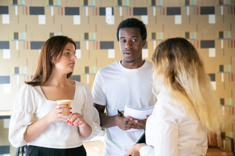 African American guy and Caucasian lady looking at blonde woman Free Photo