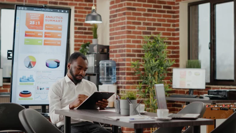 African american man greeting team of coworkers in startup office, meeting to plan project and work on business strategy. group of colleagues preparing to design financial presentation. Free Photo