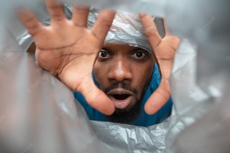 African-American man looking for something in unusual places at his home Free Photo