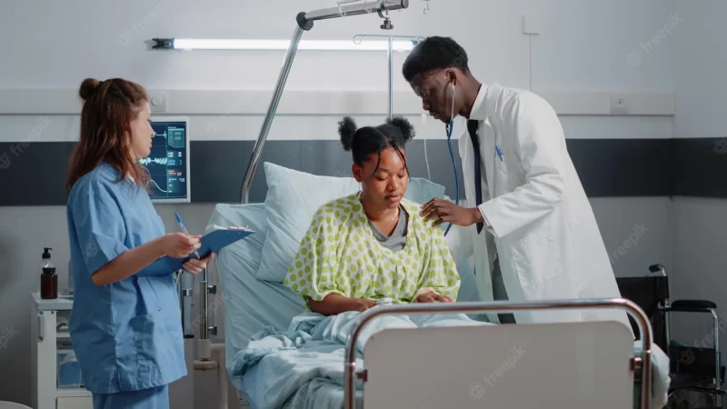 African american medic using stethoscope on ill patient to check heartbeat and do examination to cure sickness. specialist doing healthcare consultation while nurse giving assistance Free Photo