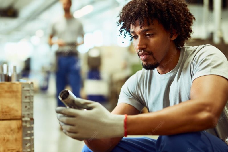 African american steel worker analyzing finished products while working in a factory Free Photo