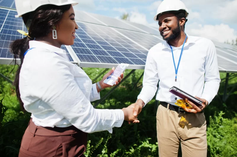 African american technician checks the maintenance of the solar panels group of three black engineers meeting at solar station and make a deal with money Free Photo