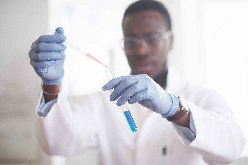 An African American worker works in a laboratory conducting experiments. Free Photo