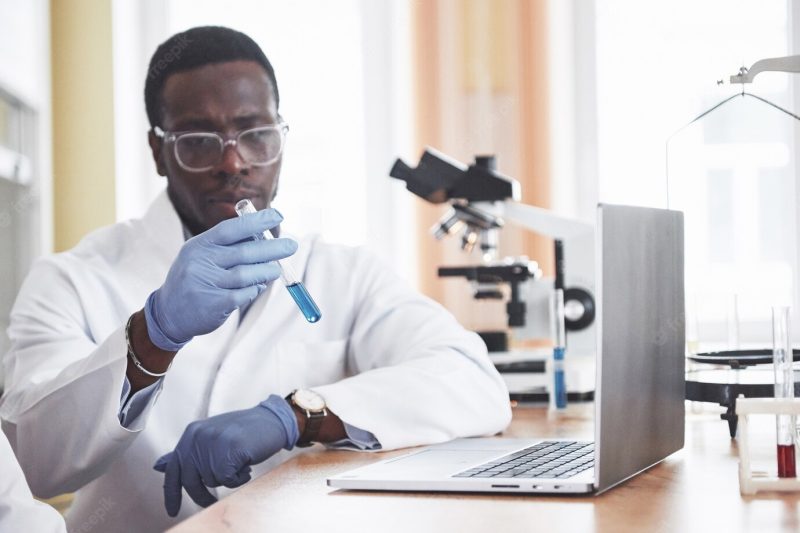 An African American worker works in a laboratory conducting experiments. Free Photo