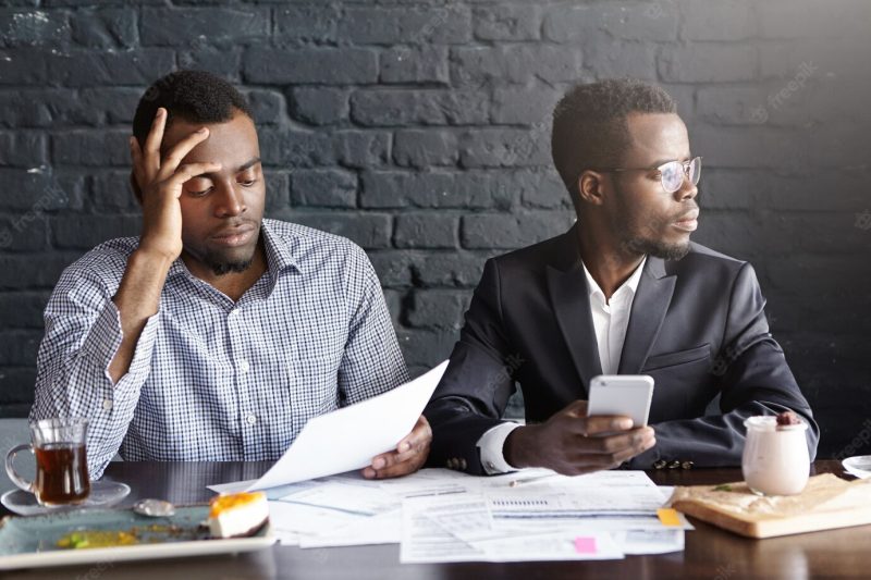 African businessman reading document in hands with frustrated look Free Photo