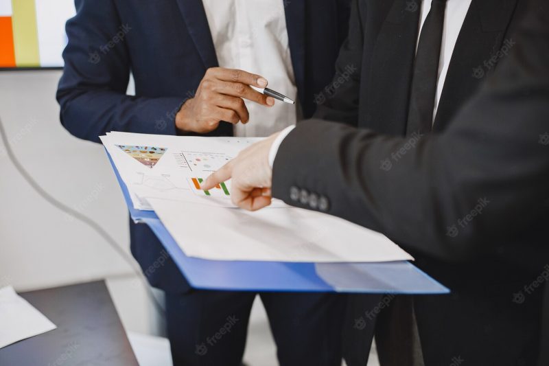 African man in a black suit. international partners. young guys with senior man. Free Photo