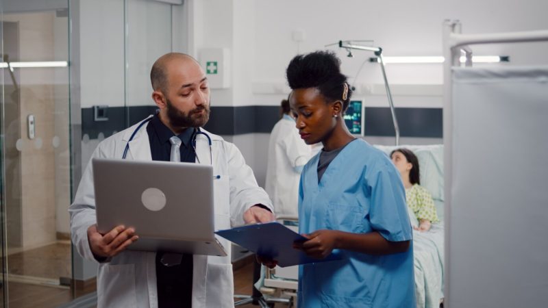 African nurse and surgeon doctor in medical uniform analyzing illness symptom working in hospital ward Free Photo