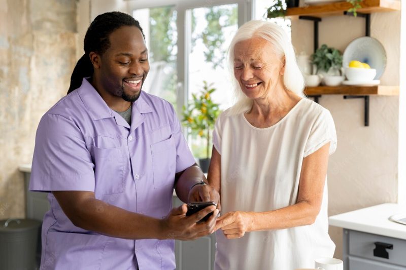 African social worker helping a senior woman Free Photo