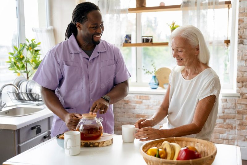 African social worker helping a senior woman Free Photo