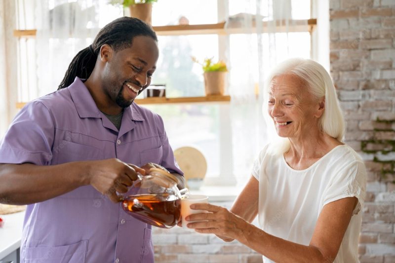 African social worker helping a senior woman Free Photo