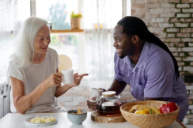 African social worker helping a senior woman Free Photo