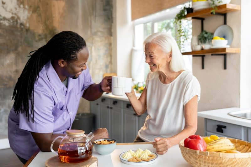 African social worker helping a senior woman Free Photo