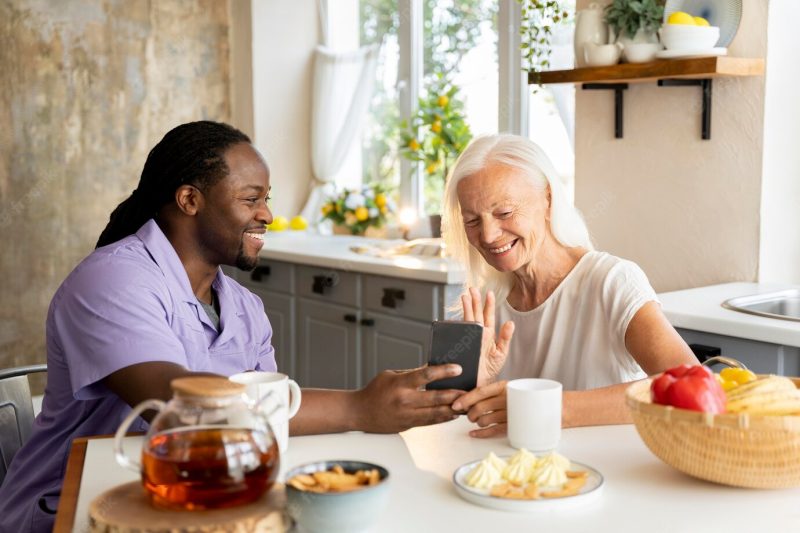 African social worker helping a senior woman Free Photo