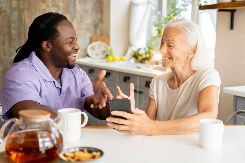 African social worker helping a senior woman Free Photo