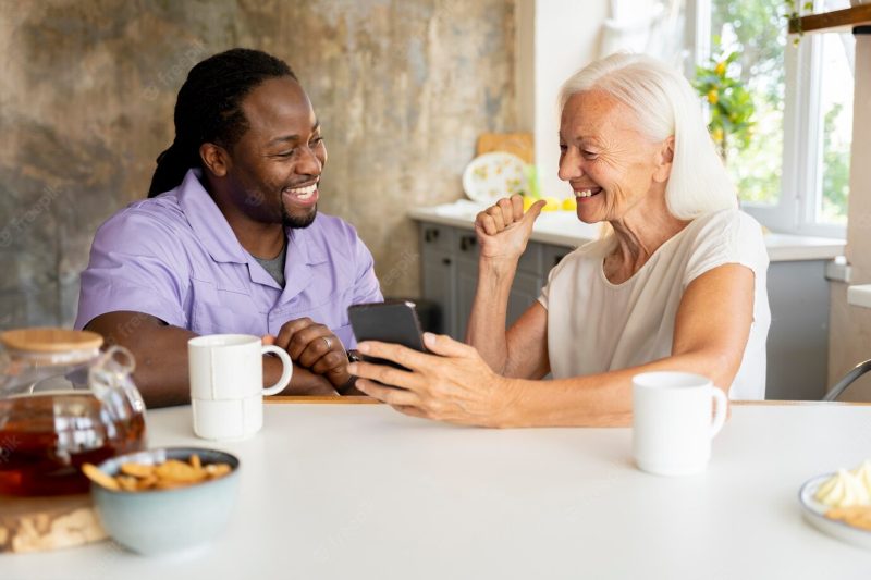 African social worker helping a senior woman Free Photo