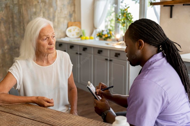 African social worker helping a senior woman Free Photo