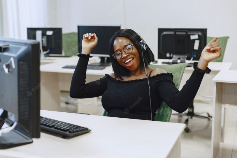 African woman sitting in computer science class. lady with glasses. female student sitting at the computer. Free Photo