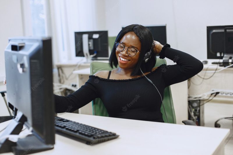 African woman sitting in computer science class. lady with glasses. female student sitting at the computer. Free Photo