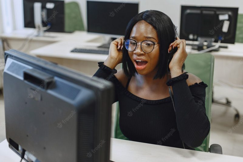 African woman sitting in computer science class. lady with glasses. female student sitting at the computer. Free Photo