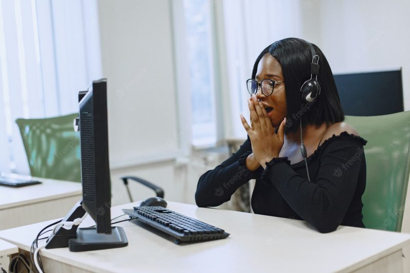 African woman sitting in computer science class. lady with glasses. female student sitting at the computer. Free Photo