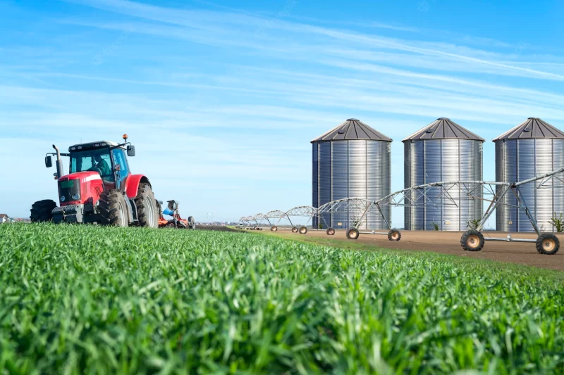 Agriculture and food production concept with tractor machine silos and irrigation system Free Photo