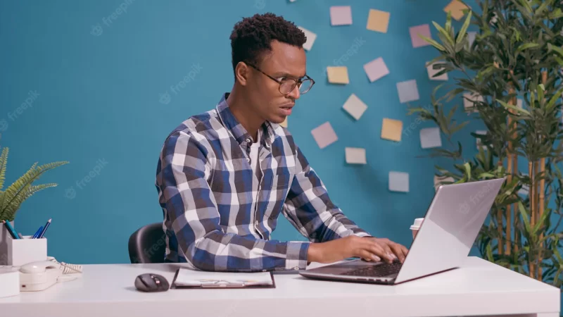 Angry employee having furious reaction about business work, feeling furious while he uses laptop computer on desk. office worker feeling annoyed and tense about job problem, freelance failure. Free Photo