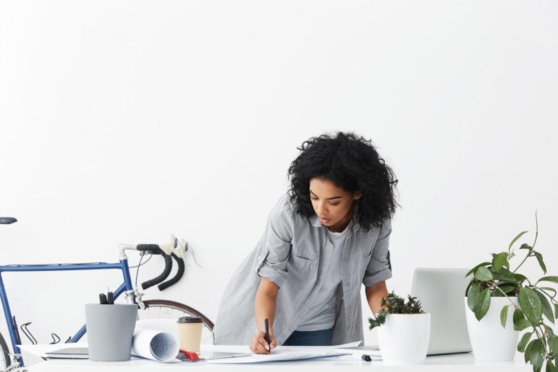 Attractive serious young African American woman engineer drawing sketch Free Photo