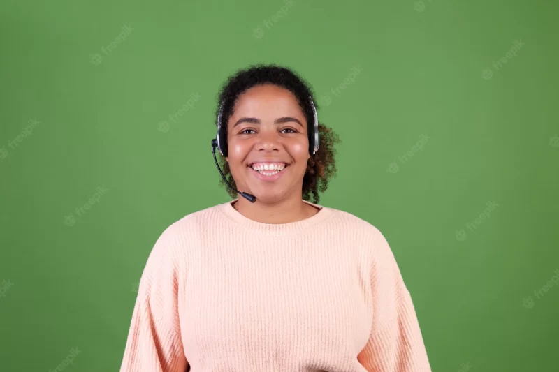 Beautiful african american woman on green wall manager call centre worker happy adorable smiling welcoming all calls Free Photo